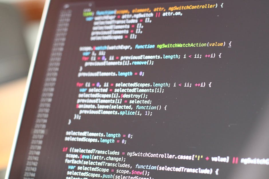A close-up view of a computer screen displaying lines of HTML and CSS code in various colors, including blue, green, yellow, and purple, on a dark background. The code consists of tags, properties, an