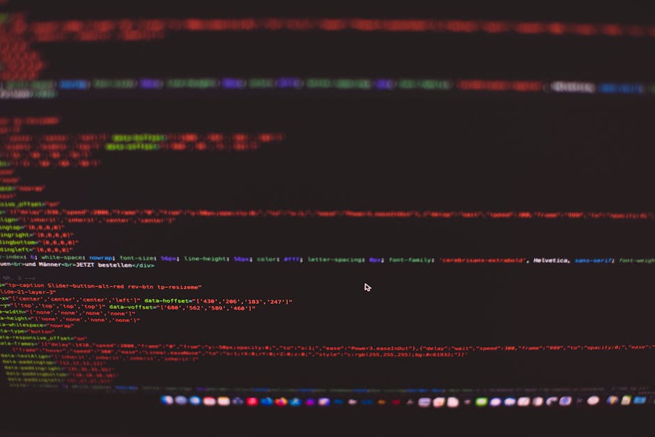 A close-up of a laptop screen displaying lines of colorful code, placed on a wooden desk with a warm, orange-toned background. The screen shows a dark-themed integrated development environment (IDE) w